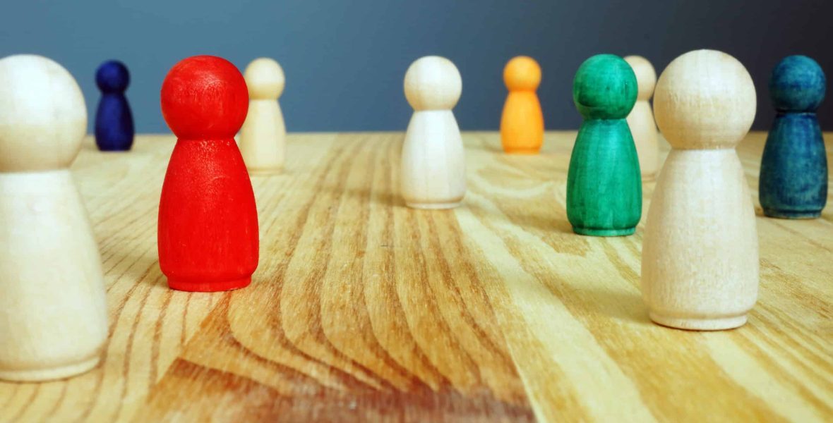 Diversity concept. Colored figures between wooden ones. Diversity concept. Colored figures between wooden ones.