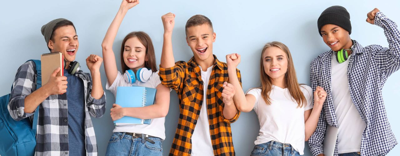 Portrait of happy young students on color background